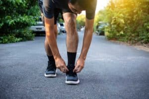 man tying his shoes before running for good health