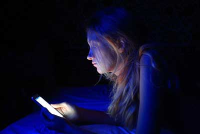young woman using smart phone in bed